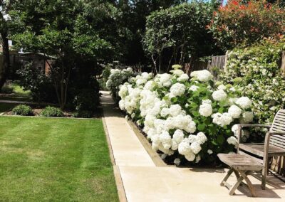 Hard landscaping, paving, lawn, flowering plants, garden furniture